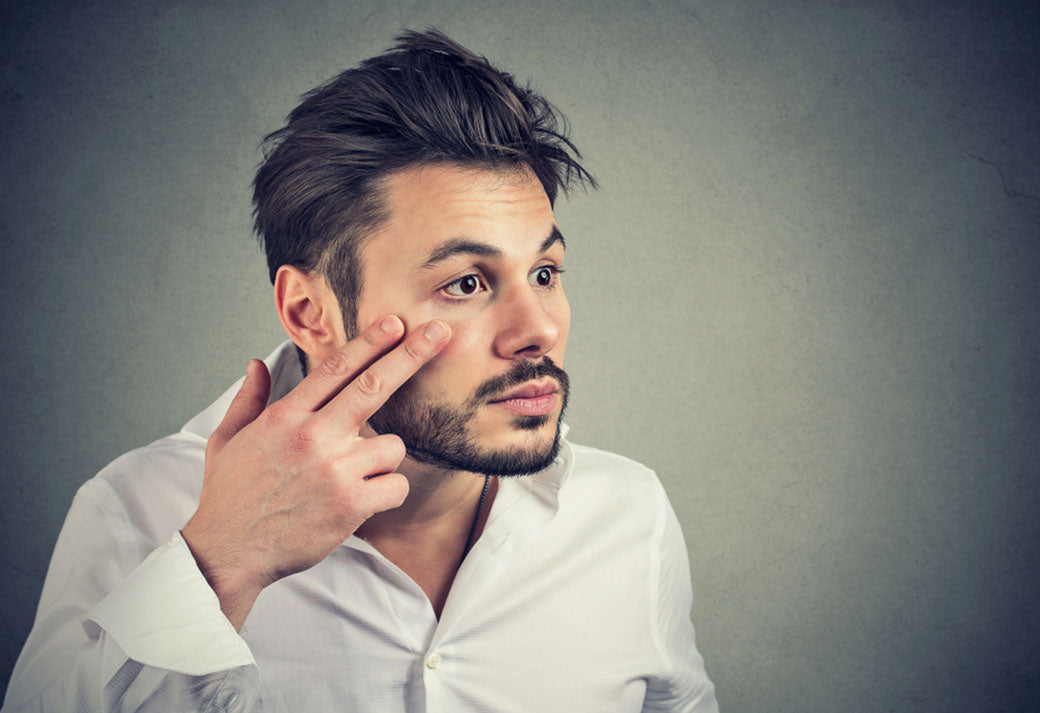 a man applying under eye cream