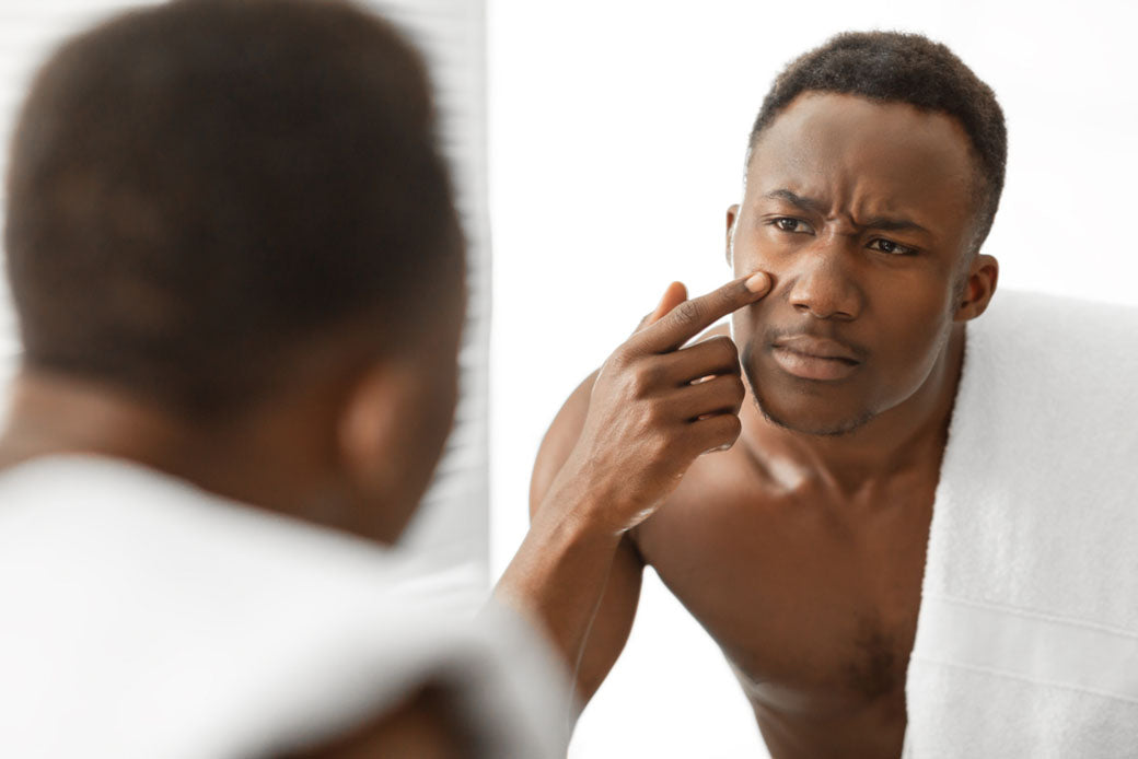 inspecting skin in bathroom mirror