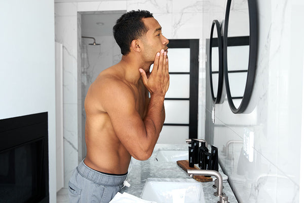 man checking face bathroom mirror