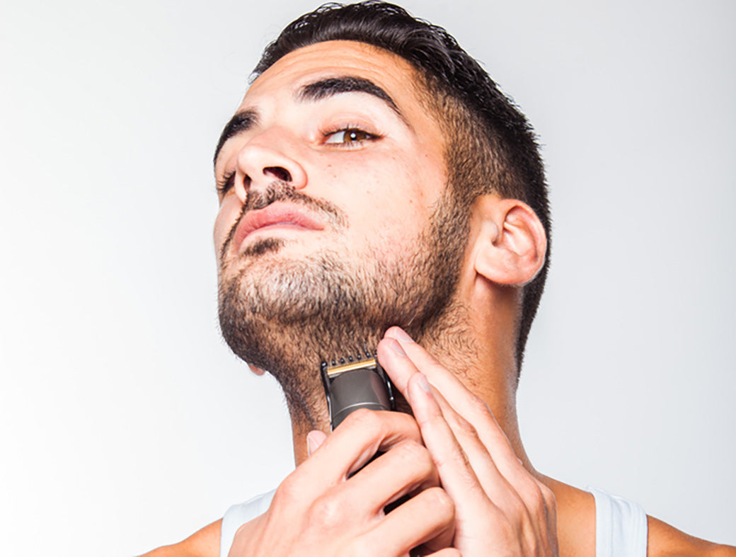 man in white shirt trimming beard