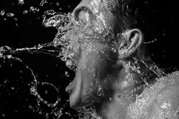 a man splashing water on his face