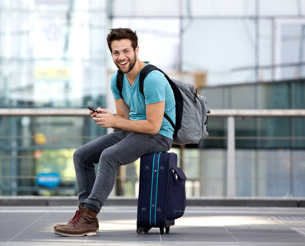 young man sitting on a suitcase